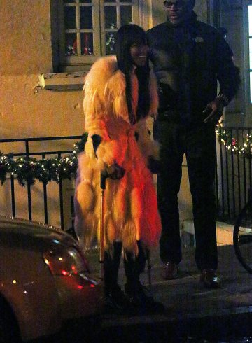 Наоми пристига на парти преди Коледа с патерици, но видимо приповдигнато настроение. Снимка: Splash news