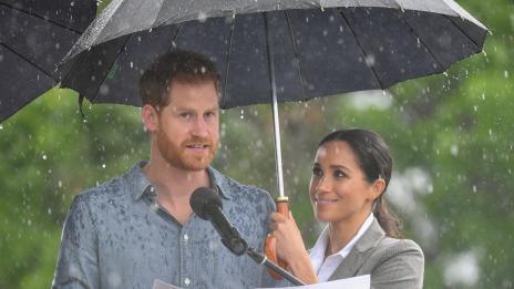 Бременната Меган пази своя принц от дъжда