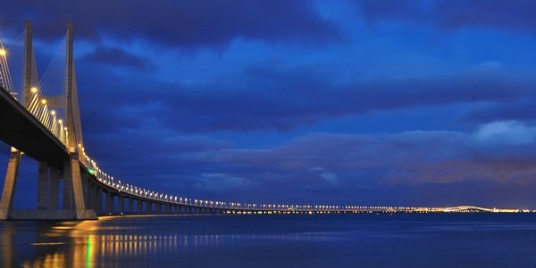 Снимка: Vasco da Gama Bridge, ЛисабонТой е най-дългият мост в Европа и е от висящ тип. Простира се над река Тежу. Открит е на 29 март 1998 година, точно по време на световното изложение „Експо 98“, с което Портогалия отпразнува 500-годишнината от откриването от Васко да Гама на морския път от Европа към Индия.